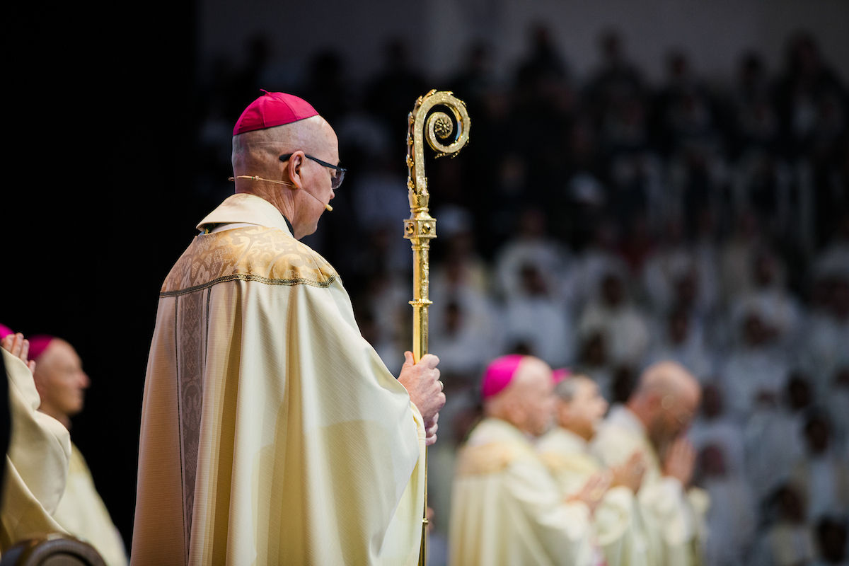 A bishop holds a crozier, symbol of his pastoral authority.