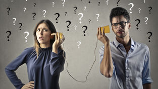 A confused man and woman use tin can phones; question marks fill the gray background, suggesting misunderstanding.