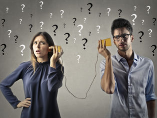 A confused man and woman use tin can phones; question marks fill the gray background, suggesting misunderstanding.