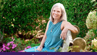 Smiling older woman in teal dress sits on a garden bench, with green hedges and pink flowers; banner reads Appeal in Action.