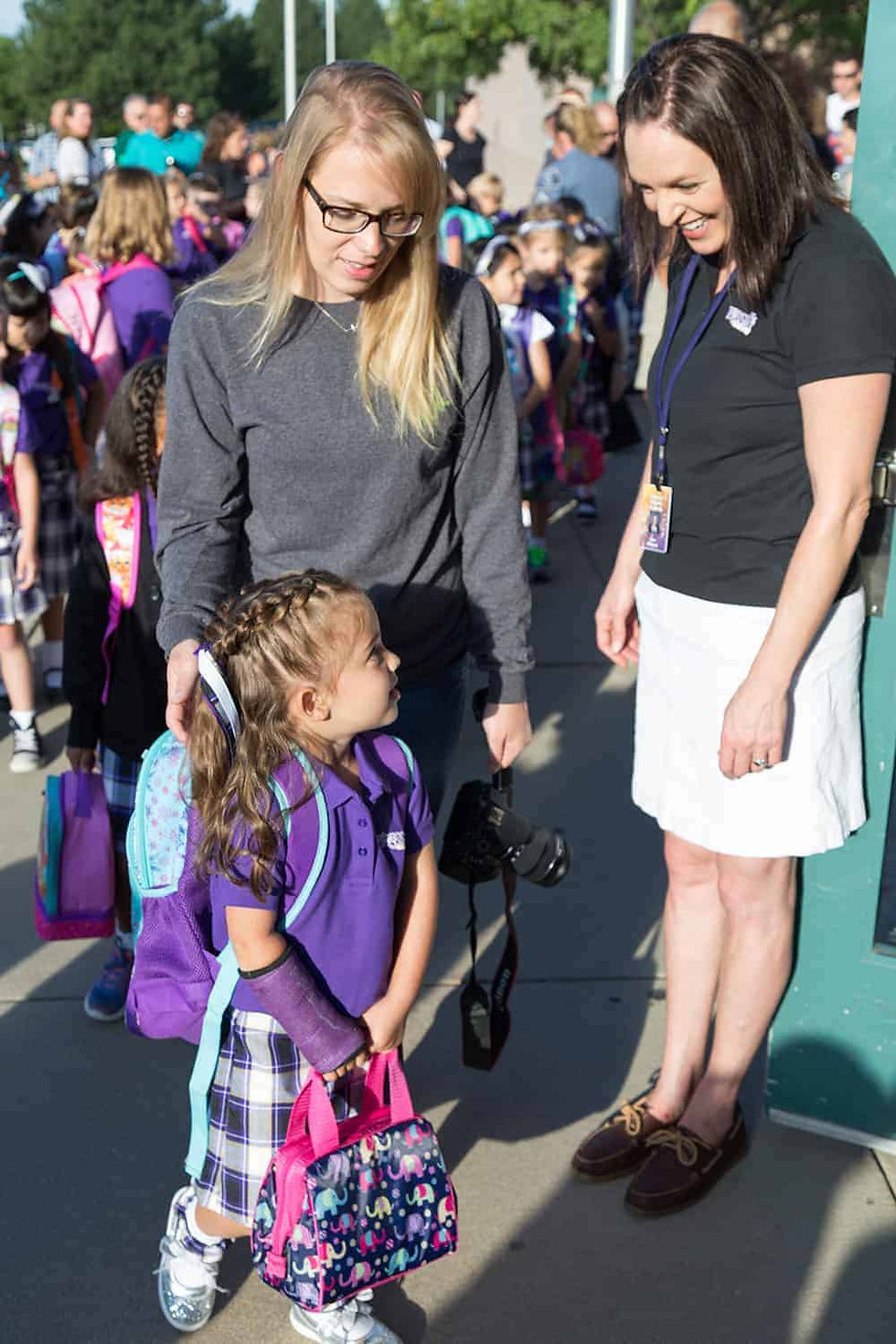 Frassati Catholic Academy principal Sara Alkayali greets a student as her mom drops her off for the first day of school. (Photo by Jason Weinrich | Denver Catholic)