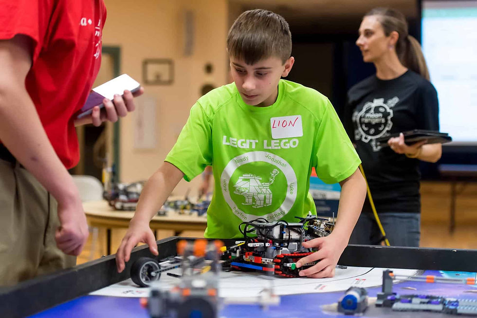 Brady Gemperline works with the team robot during Innovation Night. Photo by Daniel Petty