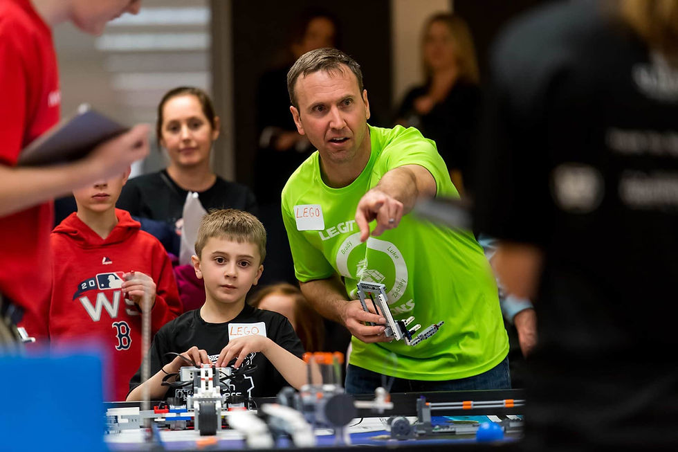 Coach Chris Gemperline (right), alongside Rowan Gemperline, guides his team during an exhibition Lego League match at the school. Photo by Daniel Petty