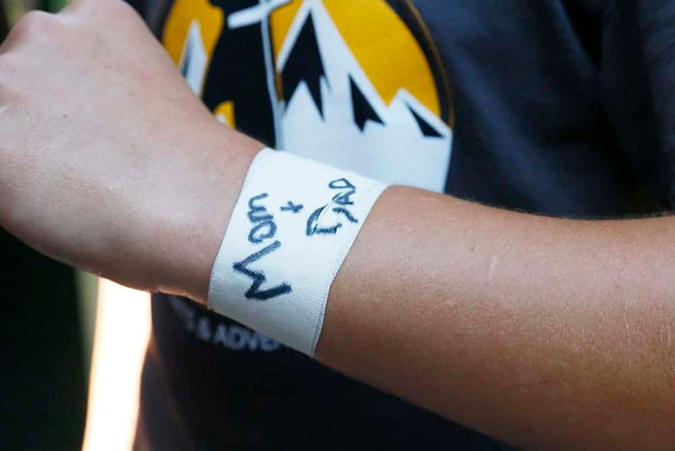 The boys wrap tape around their wrists and write the names of people they’d like to offer up the day for at camp. (Photo by Aaron Lambert)
