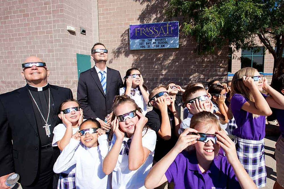 Archbishop Samuel J. Aquila and 6th grade students at Frassati Catholic Academy practice viewing the solar eclipse through special solar-viewing glasses on the first day of the brand new school Aug. 21. Archbishop Aquila blessed and dedicated the school, which is the first new school to open in the Archdiocese of Denver since 2012. (Photo by Andrew Wright | Denver Catholic)