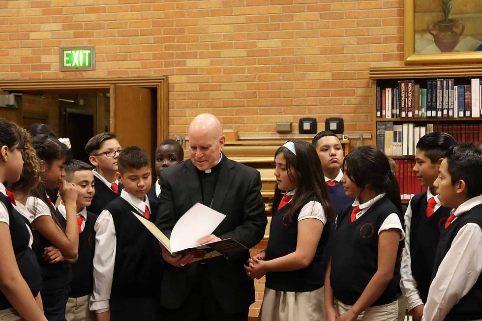 The fifth-grade class at Annunciation Catholic School presented Archbishop Samuel J. Aquila a children’s book they wrote and illustrated about Julia Greeley. Photo by Moira Cullings