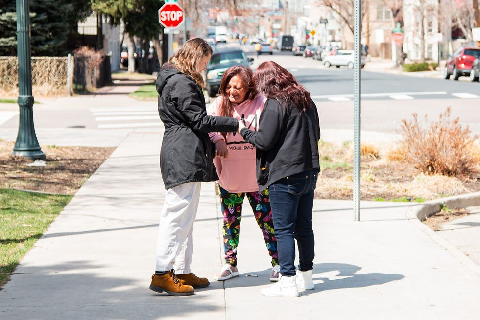 A Christ in the City missionary prays with two Lunch in the Park attendees. Lunch in the Park, a weekly community event, seeks not only to feed the homeless, but to create a space for encounter, fellowship, and community. (Photo: André Escaleira, Jr.)