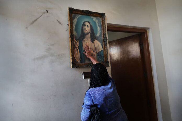 BAGHDAD, IRAQ - JULY 24: An Iraqi Christian woman touches a picture of Jesus before a Sunday service at St. Joseph Chaldean Church on July 24, 2011 in Baghdad, Iraq. Forming one of the oldest Christian communities of the Middle East, Iraqi Christians have been targeted for attack since 2003, with numerous abductions, murders and threats for them to leave Iraq. In 1980 Iraqi Christians made up over 7% of the population and have now declined to below 3%. St Joseph, which was established in 1959 and which once had as many as 1,200 families in its parish, now has only 150 to 200 families left. Christians across the Middle East have been experiencing similar threats to their communities and businesses as the Arab Spring unleashes pent-up hostilities and economic uncertainty. (Photo by Spencer Platt/Getty Images)