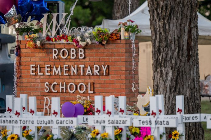 A memorial is seen surrounding the Robb Elementary School sign following the mass shooting at Robb Elementary School on May 26, 2022 in Uvalde, Texas. According to reports, 19 students and 2 adults were killed, with the gunman fatally shot by law enforcement. (Photo by Brandon Bell/Getty Images)