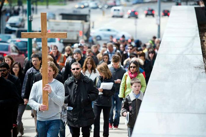 DENVER, CO - APRIL 3: Cross bearer Matthew Gear carries the cross along Colfax Avenue near Sherman Street during a Way of the Cross March on Good Friday on April 3, 2015 in Denver, Colorado. (Photo by Daniel Petty/Denver Catholic)