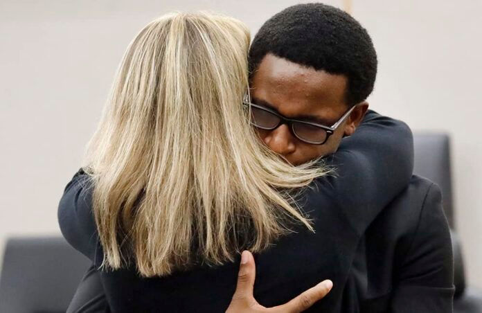Botham Jean's younger brother Brandt Jean hugs former Dallas police officer Amber Guyger after delivering his impact statement to her in Dallas, Wednesday, Oct. 2, 2019. Guyger has been sentenced to 10 years in prison for killing her black neighbor in his apartment, which she said she mistook for her own unit one floor below. (Tom Fox/The Dallas Morning News via AP, Pool)