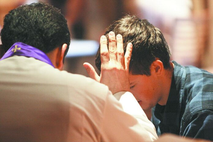 Father Rob Trujillo of Epiphany Church in Lake City, Fla., hears a young man's confession during a pro-life gathering at the Verizon Center in Washington Jan. 23. Tens of thousands of young people gathered at two Washington arenas to rally and pray before taking part in the annual March for Life. (CNS photo/Gregory A. Shemitz) (Jan. 23, 2012) See LIFE-YOUTH Jan. 23, 2012.