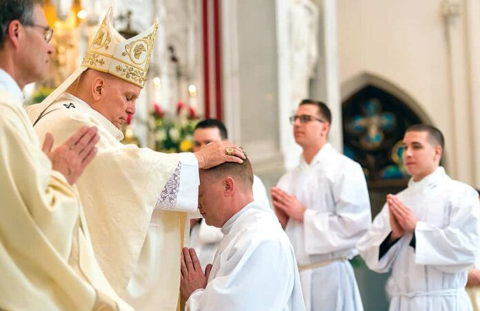 DENVER, CO - FEBRUARY 22: Denver Archbishop Samuel Aquila (L) places hands on the head of John Croghan (R) during Croghan’s transitional deacon ordination for the Archdiocese of Denver at the Cathedral Basilica of the Immaculate Conception on February 22, 2020, in Denver, Colorado. (Photo by Daniel Petty/Denver Catholic)