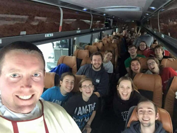 Father Steve Mills of St. Thomas Aquinas Newman Center at the University of Nebraska in Lincoln snaps a selfie with college students before celebrating a vigil Mass on a bus. This group was stranded on the Pennsylvania Turnpike leaving from the March for Life due to a torrential blizzard.