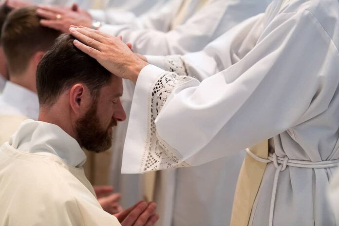 DENVER, CO - MAY 13: Francesco Basso prays as priests lay their hands upon him during his ordination to the priesthood at the Cathedral Basilica of the Immaculate Conception on May 13, 2017, in Denver, Colorado. (Photo by Daniel Petty/for Denver Catholic)