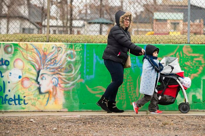 DENVER, CO - DECEMBER 14: A woman walks on the sidewalk with her boy during a procession celebrating Our Lady of Guadalupe around the neighborhood of Our Lady of Guadalupe Church on December 14, 2014, in Denver, Colorado. (Photo by Daniel Petty/Denver Catholic Register)