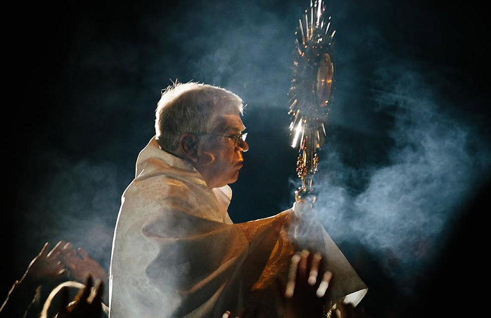 Father Doug Grandon holds the Blessed Sacrament during a Eucharistic Procession. (Photo by Grant Whitty on Unsplash)