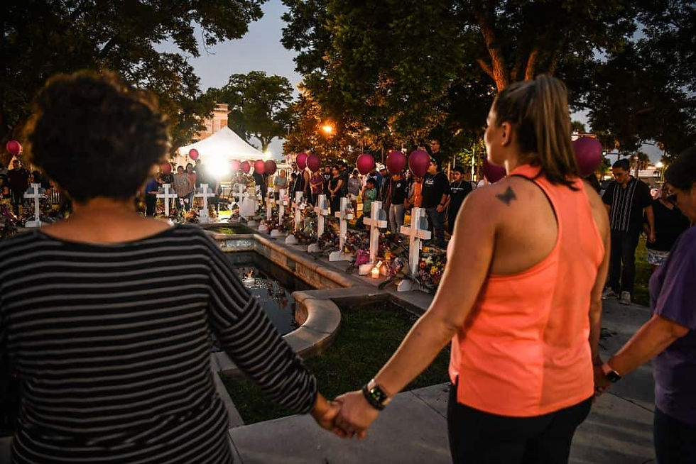 People make a human chain as they pay tribute to the victims around a makeshift memorial in front of the Uvalde County Courthouse in Uvalde, Texas, May 26, 2022. (Photo by CHANDAN KHANNA / AFP)