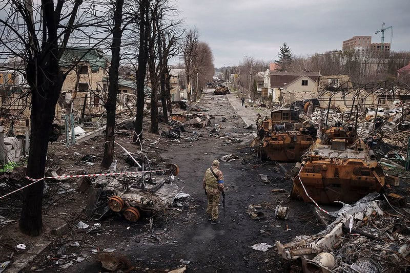 A Ukrainian serviceman walks amid destroyed Russian tanks in Bucha, on the outskirts of Kyiv, Ukraine, Wednesday, April 6, 2022. (AP Photo/Felipe Dana/manhhai via flickr)