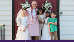 Smiling woman and four children in formal clothes stand on a porch with floral wreaths; banner reads Appeal in Action.