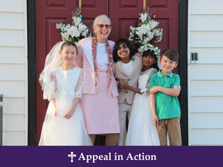 Smiling woman and four children in formal clothes stand on a porch with floral wreaths; banner reads Appeal in Action.