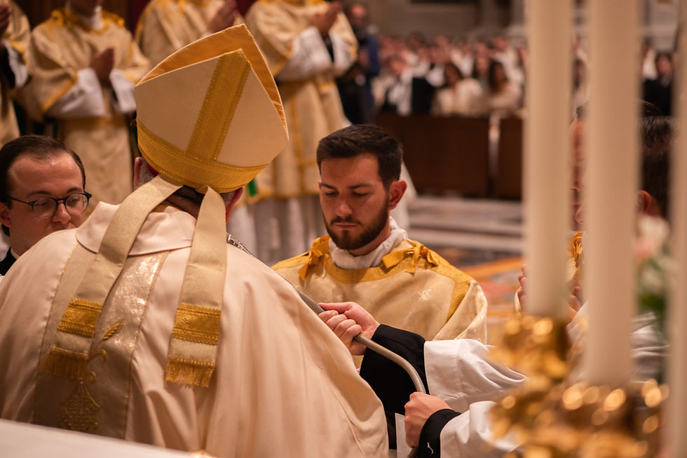 Catholic ordination ceremony with bishop in gold vestments and a kneeling man receiving a paten in a church
