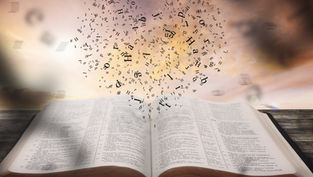 Open Bible on a wooden table with black letters rising into a cloudy sunset sky, suggesting inspiration and reverence