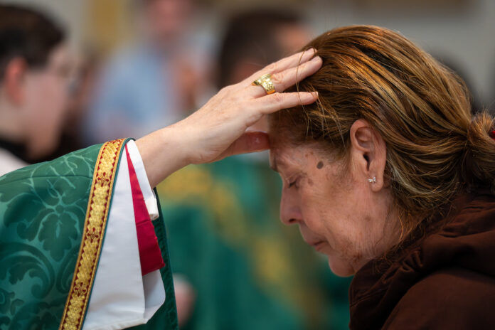 DENVER, CO - FEBRUARY 11: Denver Archbishop Samuel Aquila applies the oil of the sick to the forehead of a woman during the World Day of the Sick Healing Mass at the the Cathedral Basilica of the Immaculate Conception on February 11, 2024, in Denver, Colorado. (Photo by Daniel Petty/Denver Catholic)