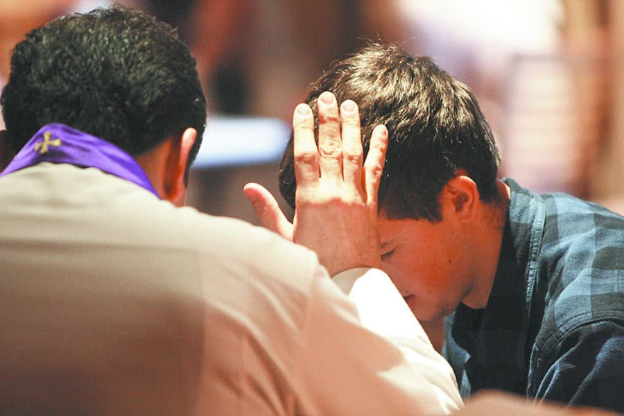 Father Rob Trujillo of Epiphany Church in Lake City, Fla., hears a young man's confession during a pro-life gathering at the Verizon Center in Washington Jan. 23. Tens of thousands of young people gathered at two Washington arenas to rally and pray before taking part in the annual March for Life. (CNS photo/Gregory A. Shemitz) (Jan. 23, 2012) See LIFE-YOUTH Jan. 23, 2012.