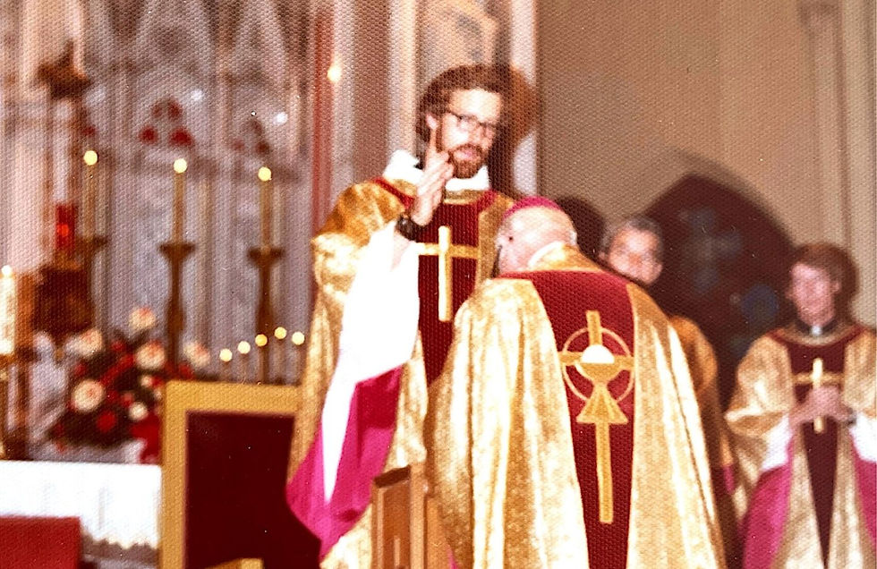 Monsignor Bernie Schmidt gives a blessing at the altar, surrounded by candles and a gathering.