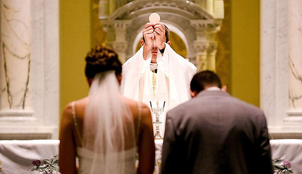 Bride and groom kneeling before the Eucharist