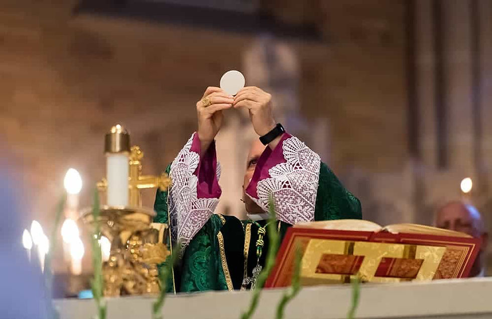 Archbishop Aquila lifting the Eucharist