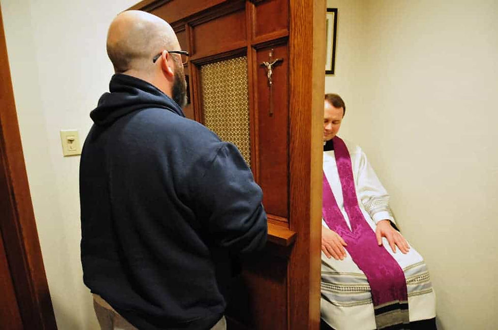 Father Andreas Hoeck and a layman enact a person going to confession behind a screen. (Photo provided)