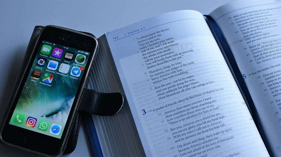 Cell phone next to open Bible