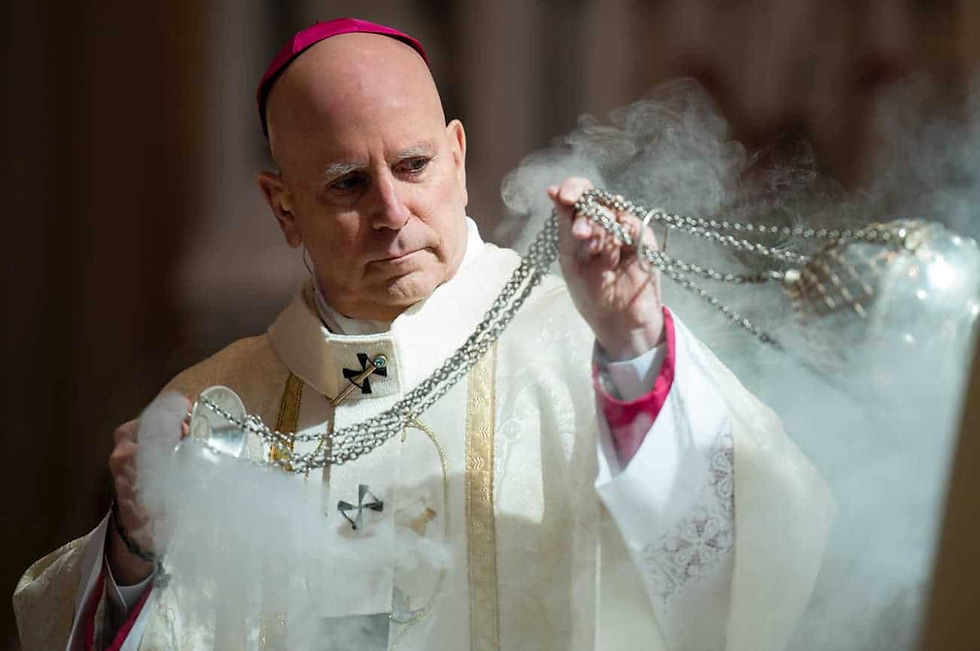 Archbishop Samuel J. Aquila reverently blesses the holy oils with incense during the Chrism Mass