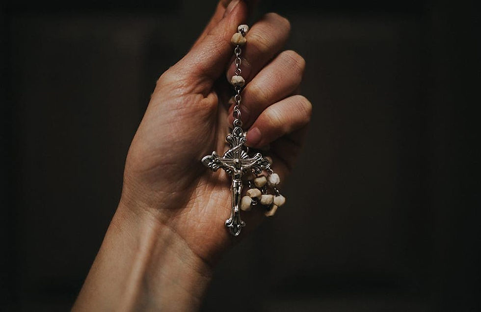 A hand holding a rosary
