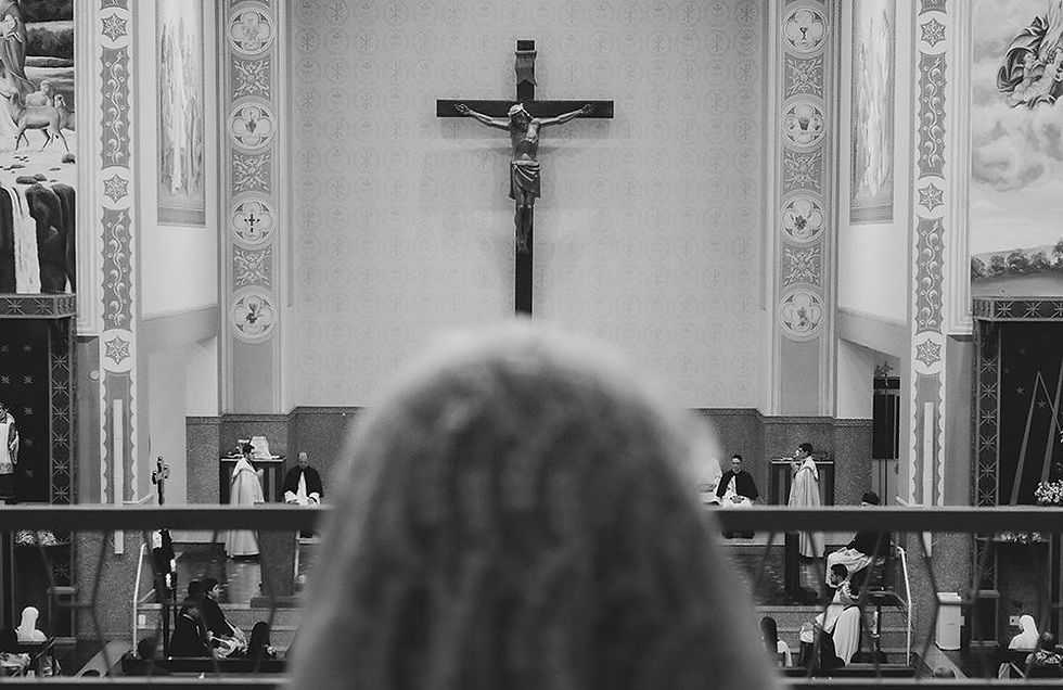 Woman looking out on church with crucifix