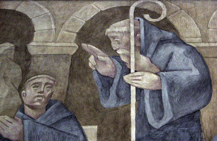 St. Benedict of Nursia raising a hand in blessing over another man