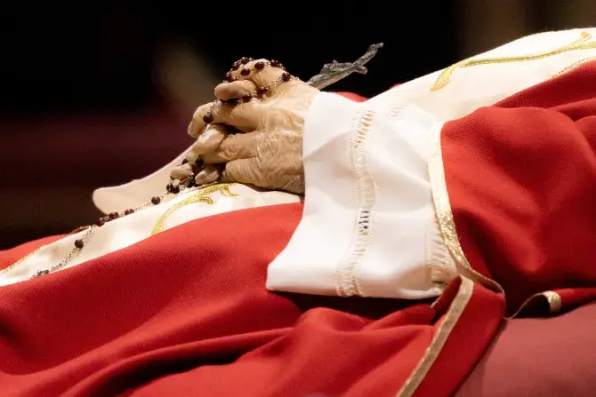 Rosary beads entwined in the hands of the late Pope Emeritus Benedict XVI as his body lies in state on Jan. 3, 2023, in St. Peter's Basilica. (Photo by Daniel Ibañez/CNA)