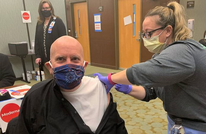 Archbishop Samuel Aquila receives the first dose of the Moderna vaccine, administered by Amy Lantzy, MS, RN, CHFN at St. Anthony’s Hospital in Lakewood. (Photo: Denver Catholic Staff)