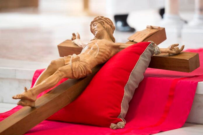 A cross rests on a pillow before being venerated