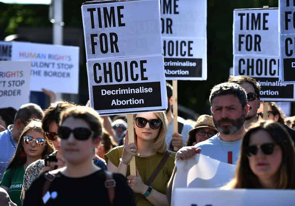 Group of people holding signs in support of decriminalizing abortion