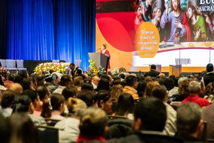 Speaker gives a talk on the Eucharist to a crowded room