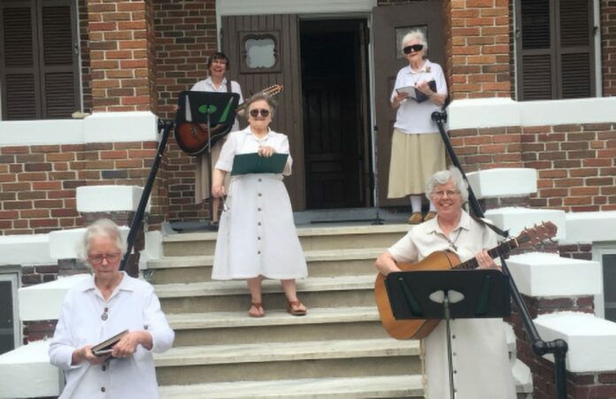 Poor Clare Sisters of New Orleans sing on the steps of their monastery on Easter, April 12, 2020. "We sang our hearts out for a handful of friends who assembled while distancing on the sidewalk," said Sister Julie Glaeser. (CNS photo/Poor Clares of New Orleans via Clarion Herald) See NEW-ORLEANS-POOR-CLARES-MARY April 15, 2020.