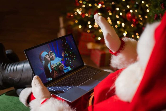 Happy mom and son talking to santa claus by video chat on a laptop. Woman and boy remotely wishes Merry Christmas. (Photo: Adobe Suite)