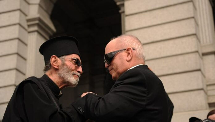 Archbishop Samuel J. Aquila greets Father Ambrose Omayas