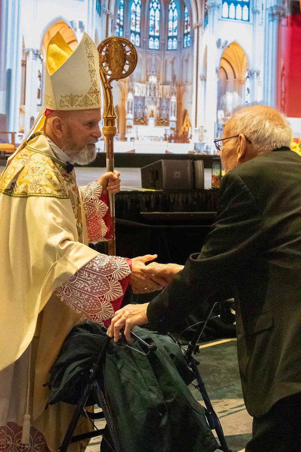 Archbishop Aquila greets Father Peter Urban, the oldest priest in the Archdiocese of Denver.