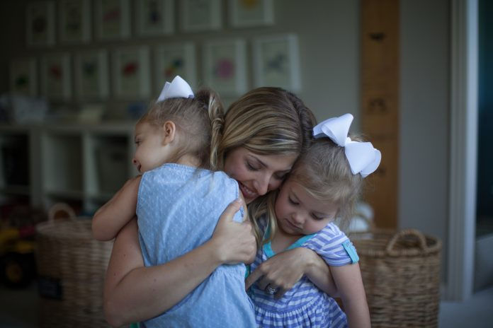 Mom hugging her two children