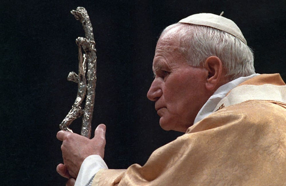 St. John Paul II looking at a crucifix
