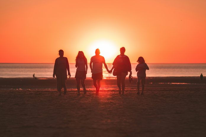 Family walking on the beach during sunset
